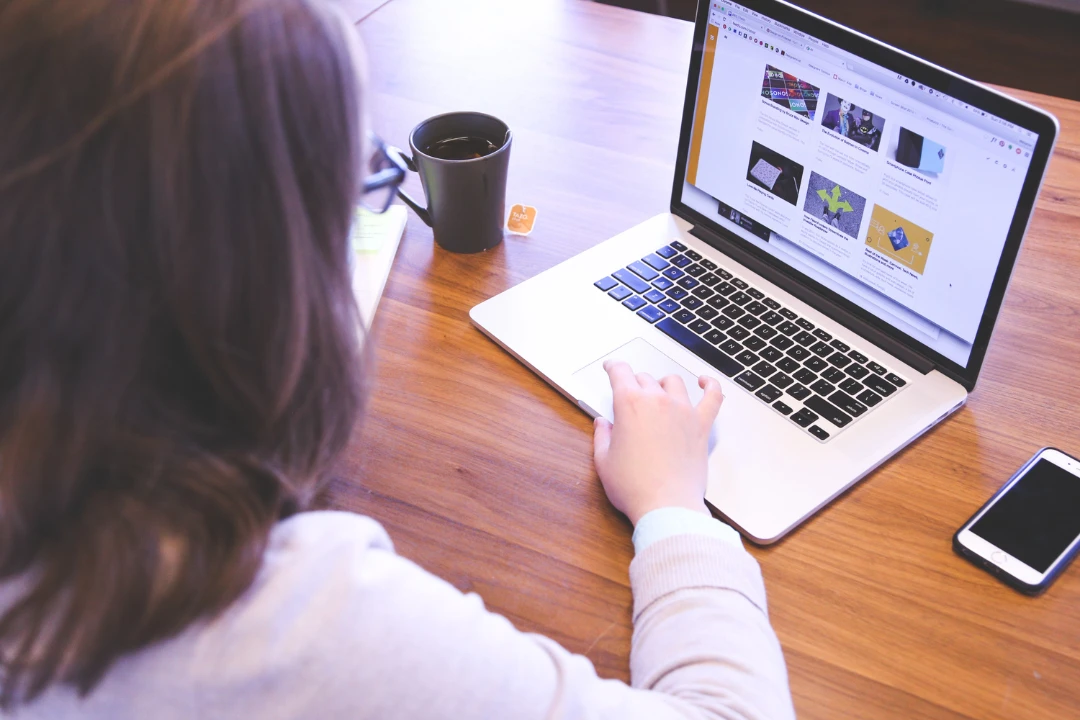 A girl doing website audit with her laptop while drinking coffee